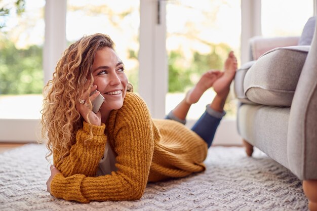 mujer, en, tibio, puente, acostado, en, piso, en casa, hablar, en, teléfono móvil