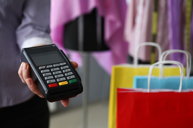 Mujer en la tienda ofrece terminal de cliente pos