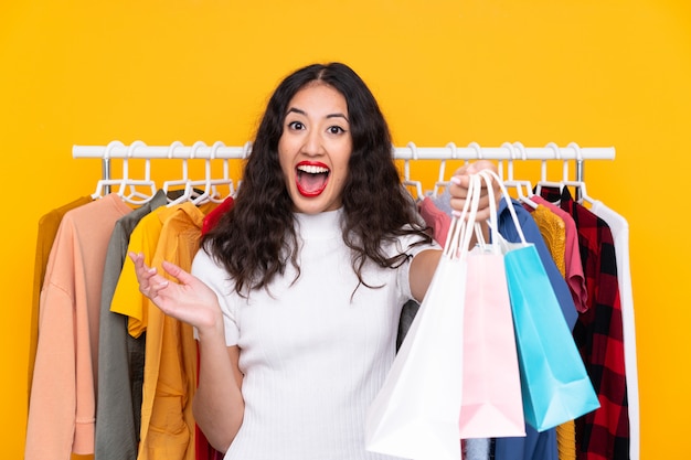 Mujer en una tienda de ropa y con bolsas de compras