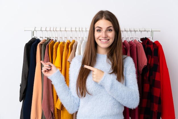 Mujer en una tienda de ropa con mucha ropa detrás