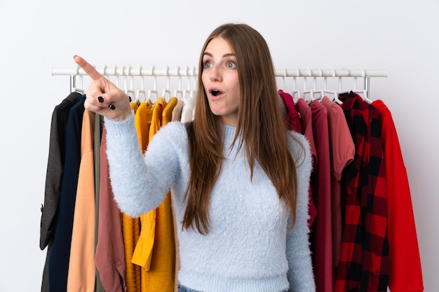 Foto mujer en una tienda de ropa con mucha ropa detrás