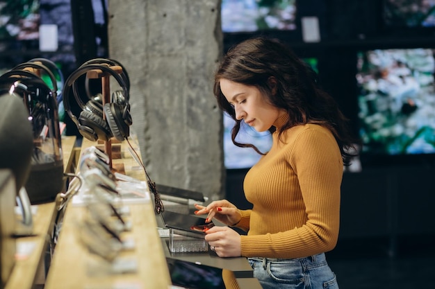 Mujer en una tienda de tecnología elige una tableta