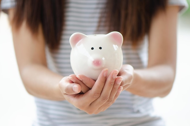 La mujer tiene una alcancía para invertir, ahorra dinero o se jubila en el futuro con espacio para copiar