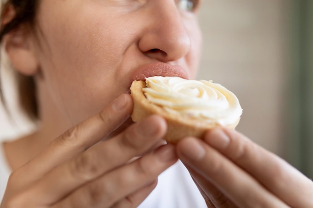 La mujer tiene antojo de comida dulce y come un pastel