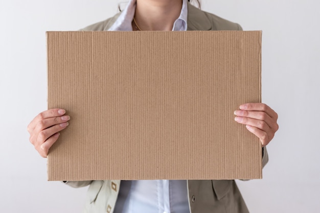 Una mujer tiene un cartel en blanco frente a su cara