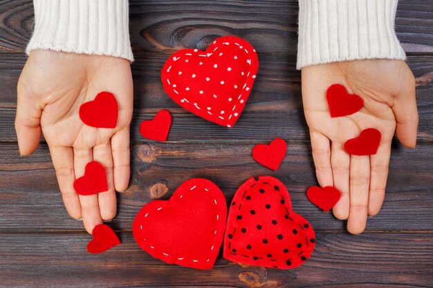 Foto una mujer tiene un corazón rojo en sus manos. concepto de amor