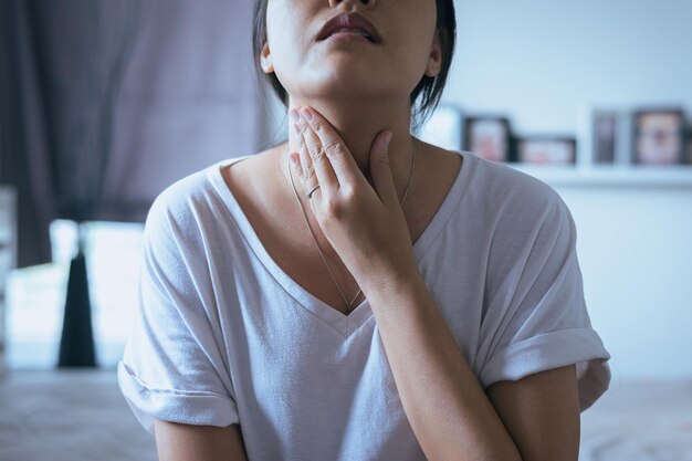 Mujer tiene dolor de garganta Mujer tocando el cuello con la mano Conceptos de salud