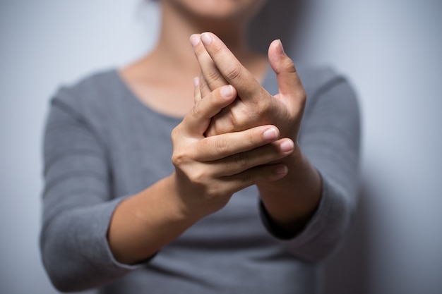 Foto la mujer tiene dolor en la mano