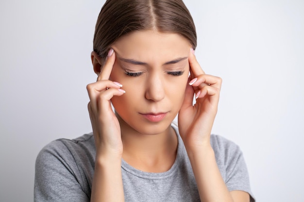 La mujer tiene un fuerte dolor de cabeza