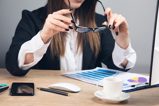 La mujer tiene gafas y lee el informe financiero