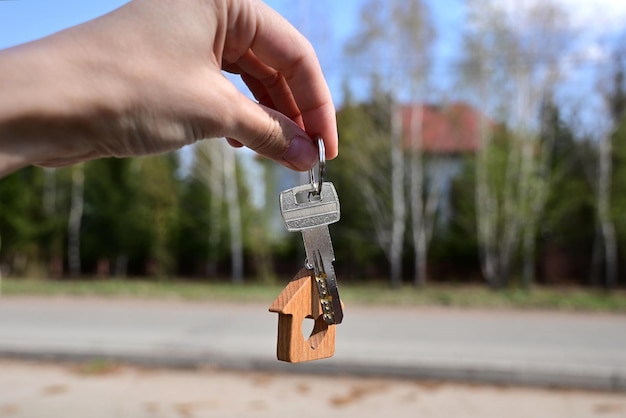 Una mujer tiene la llave de una casa nueva en la mano Préstamo de vivienda de aprobación de préstamo hipotecario