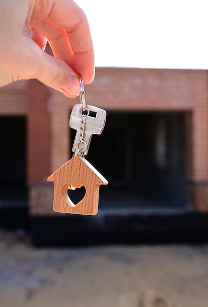 Una mujer tiene la llave de una casa nueva en la mano Préstamo de vivienda de aprobación de préstamo hipotecario
