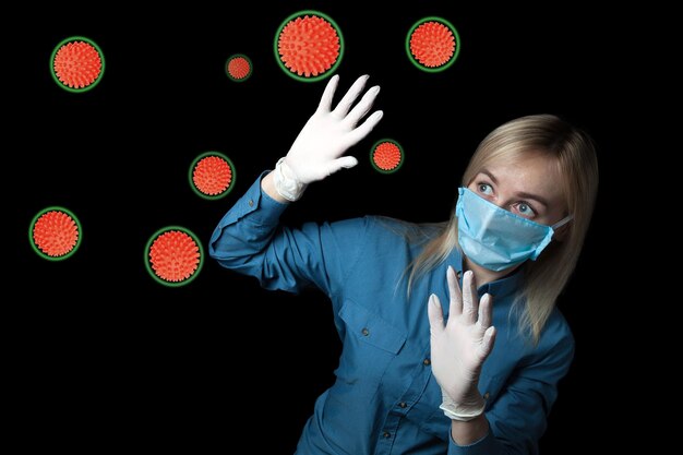 Foto la mujer tiene miedo de contraer coronavirus y está protegida por guantes de goma y una máscara médica del ataque de moléculas de la bacteria covid19