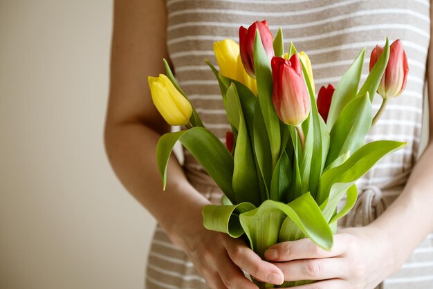 Mujer tiene ramo de flores frescas de tulipán en sus manos