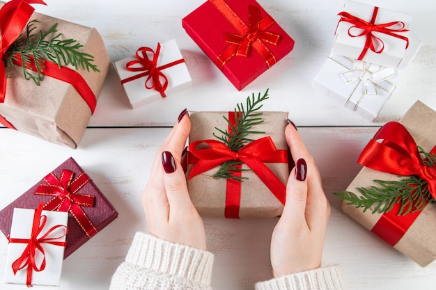 Mujer tiene en sus manos hermosa caja de regalo con lazo rojo