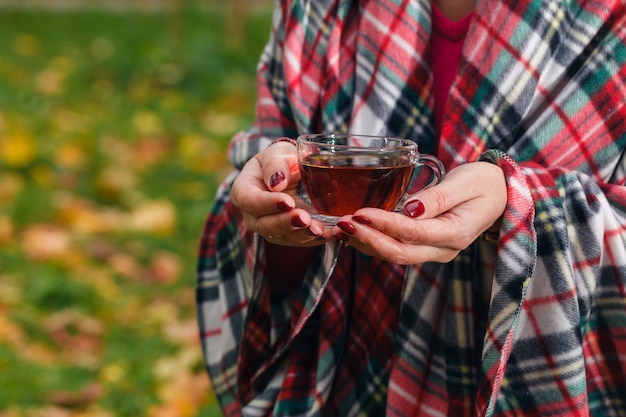 Mujer tiene un té en el parque otoño