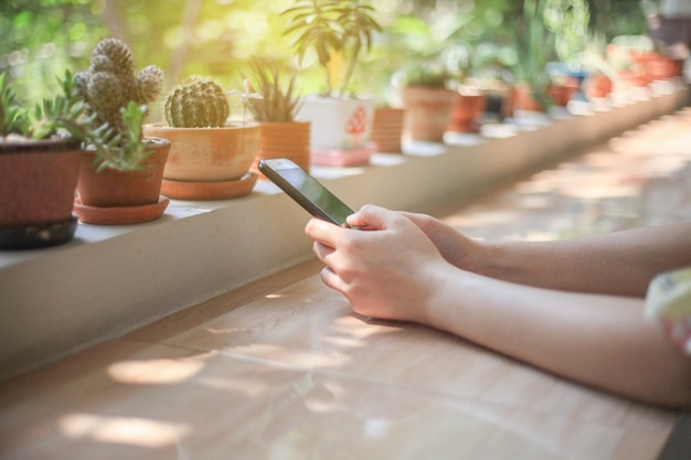 Mujer tiene teléfono inteligente Uso en línea por red internet desarrollo inalámbrico teléfono inteligente móvil Compras comerciales en cafetería, concepto de Internet