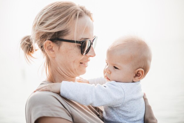 Foto mujer tierna acariciando a su pequeño bebé niño bebé al aire libre madres amor incondicional por ella