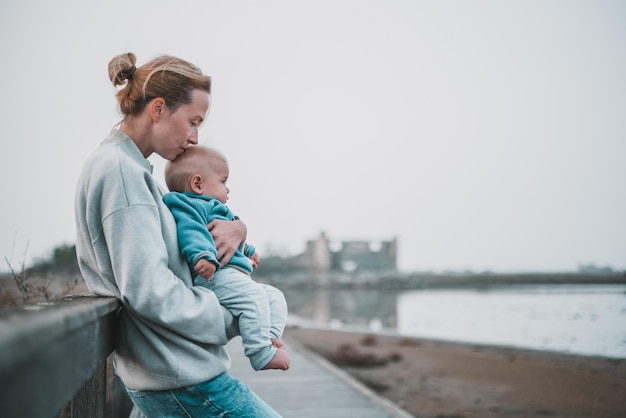 Mujer tierna acariciando a su pequeño bebé niño bebé al aire libre en un viaje de otoño a secovlje salinas