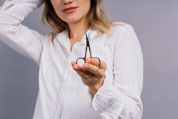 Mujer con tijeras con corte de pelo Mujer sorprendida con tijeras de pelo liso Concepto de cuidado del cabello