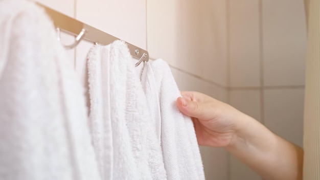 La mujer tira de la cortina y toma la toalla durante la ducha