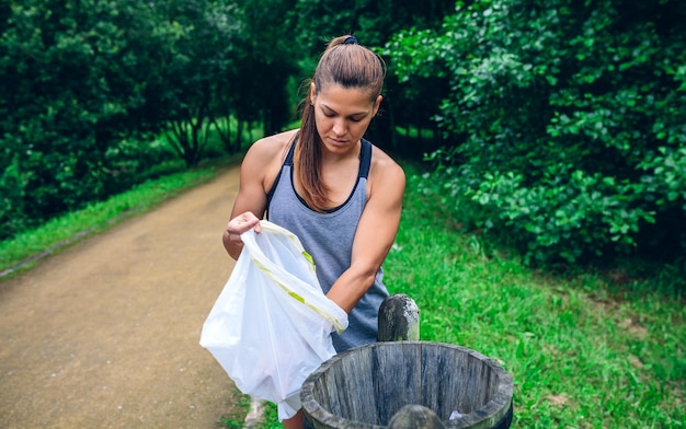 Mujer tirando basura después de plogging