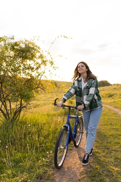 Foto mujer de tiro completo con bicicleta