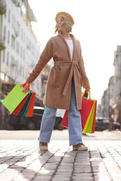 Foto mujer de tiro completo con bolsas de compras