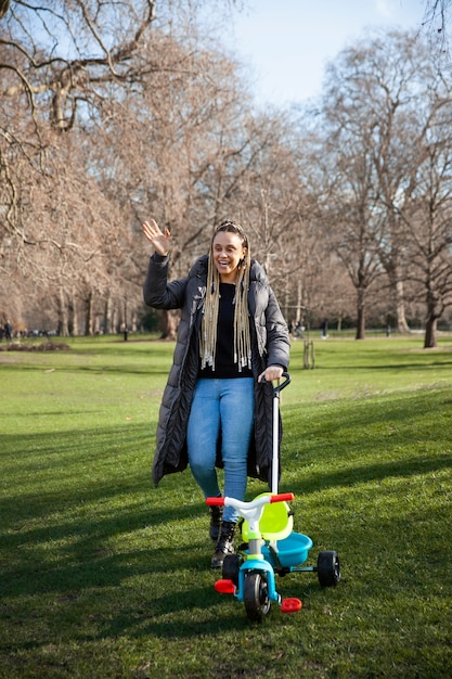 Mujer de tiro completo caminando con triciclo