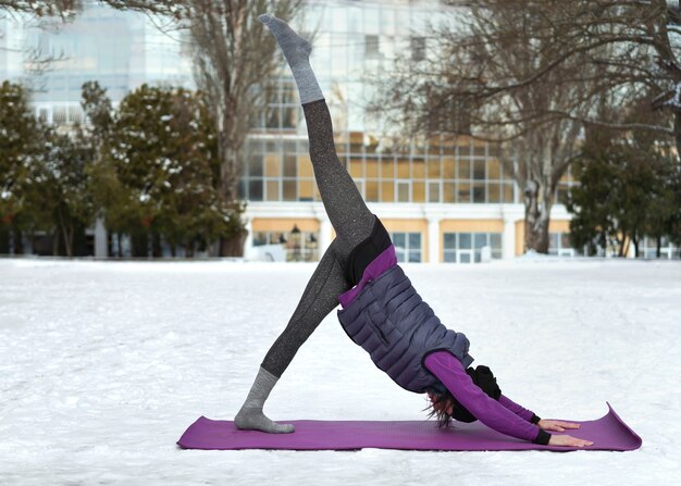 Foto mujer de tiro completo haciendo yoga en clima frío
