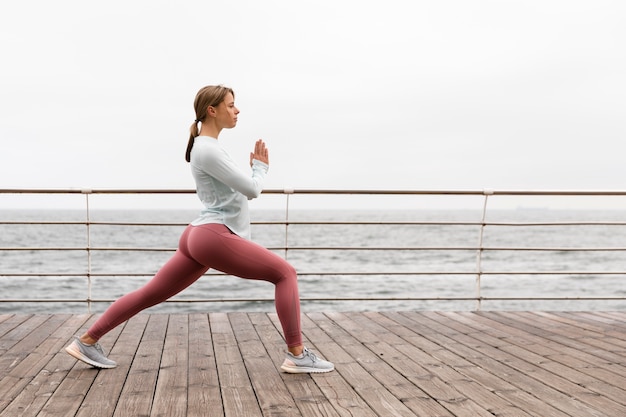 Foto mujer de tiro completo haciendo yoga