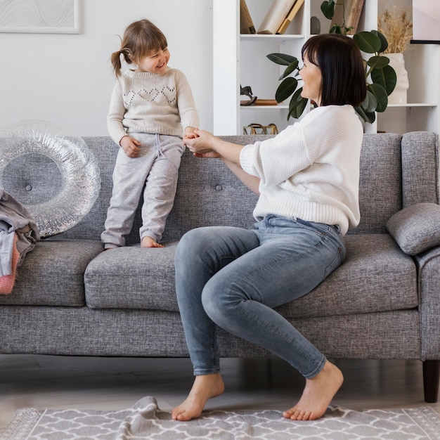 Mujer de tiro completo y niño en el sofá