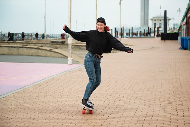 Mujer de tiro completo en patineta al aire libre