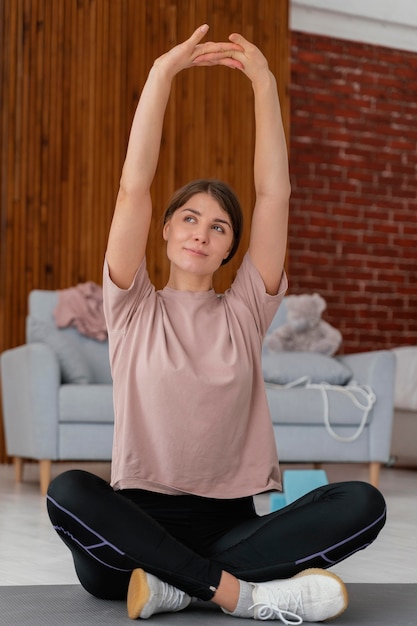 Foto mujer de tiro completo que se extiende en el piso