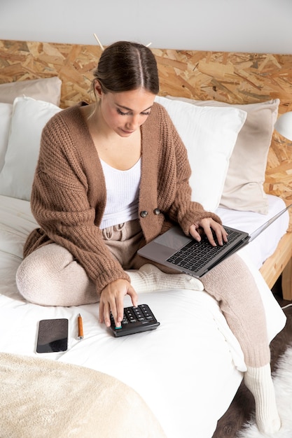 Mujer de tiro completo que trabaja con calculadora