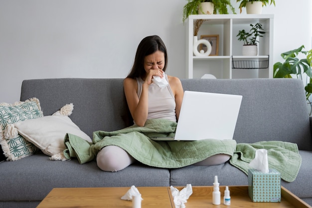 Foto mujer de tiro completo sonándose la nariz