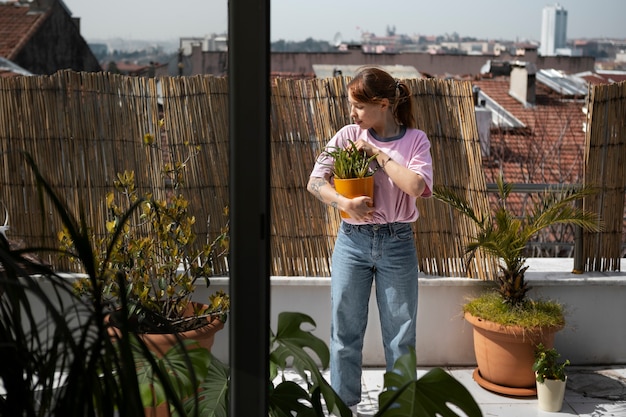 Mujer de tiro completo sosteniendo maceta