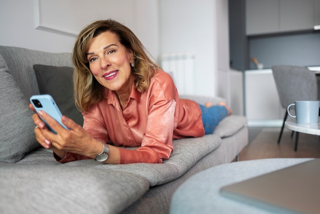 Foto mujer de tiro completo tomando un descanso con teléfono inteligente