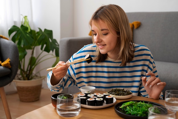 Foto mujer de tiro medio comiendo en casa