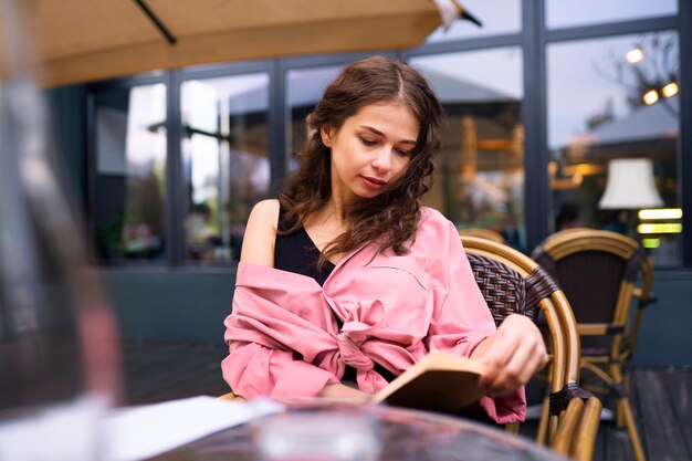 Mujer de tiro medio leyendo en el restaurante