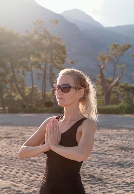 Mujer de tiro medio meditando al aire libre