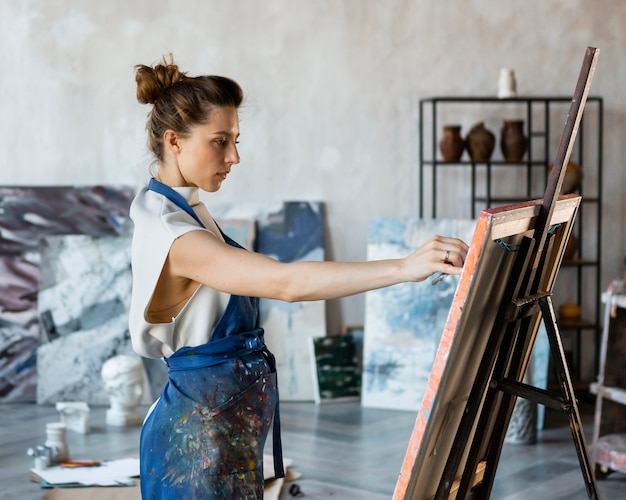 Foto mujer de tiro medio pintando en interiores