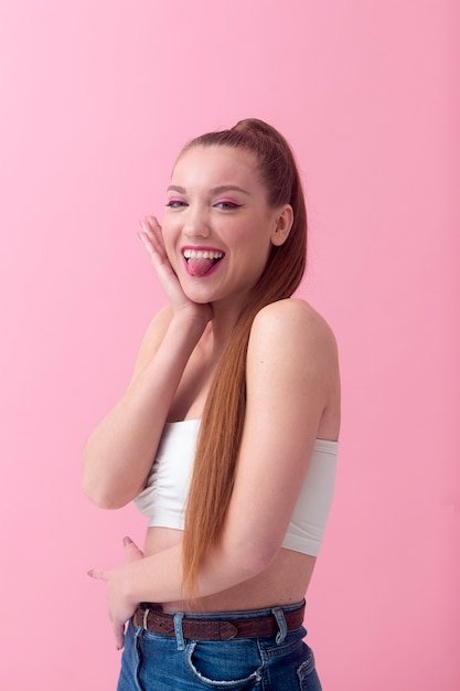 Mujer de tiro medio posando con fondo rosa