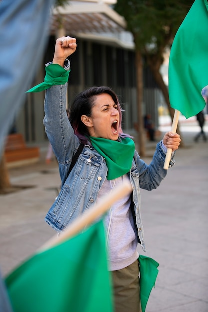 Foto mujer de tiro medio protestando al aire libre