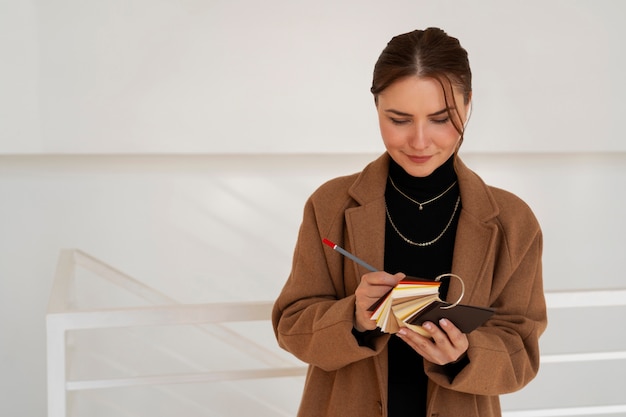 Mujer de tiro medio que trabaja en un proyecto de diseño de interiores.