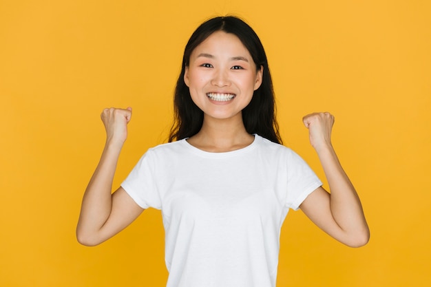 Mujer de tiro medio, sonriente, victoriosa.