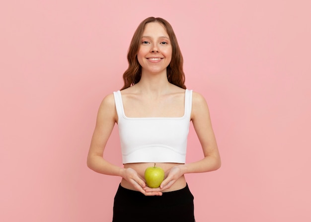 Mujer de tiro medio sosteniendo apple