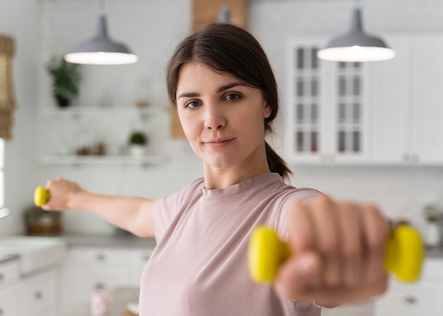 Mujer de tiro medio sosteniendo pesas