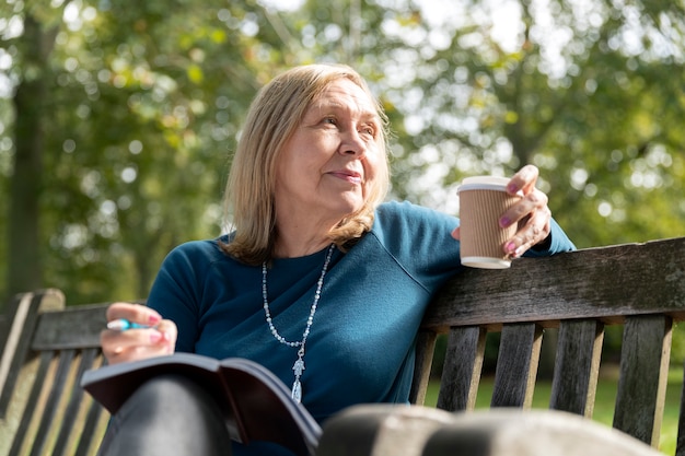 Foto mujer de tiro medio sosteniendo la taza de café