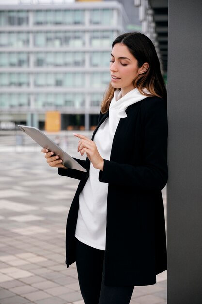 Mujer de tiro medio con tableta al aire libre